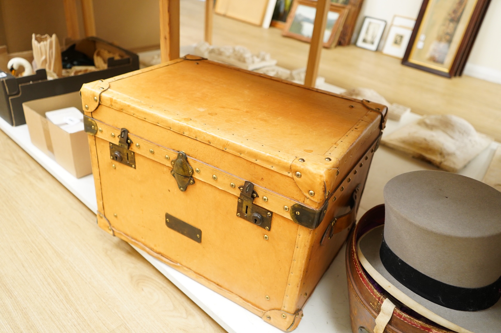 A leather trunk and top hat in box